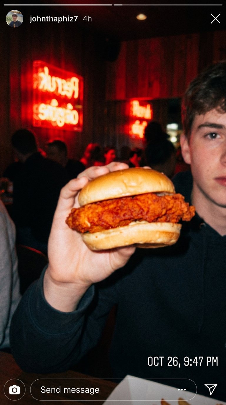 Customer holding a hot chicken sandwich